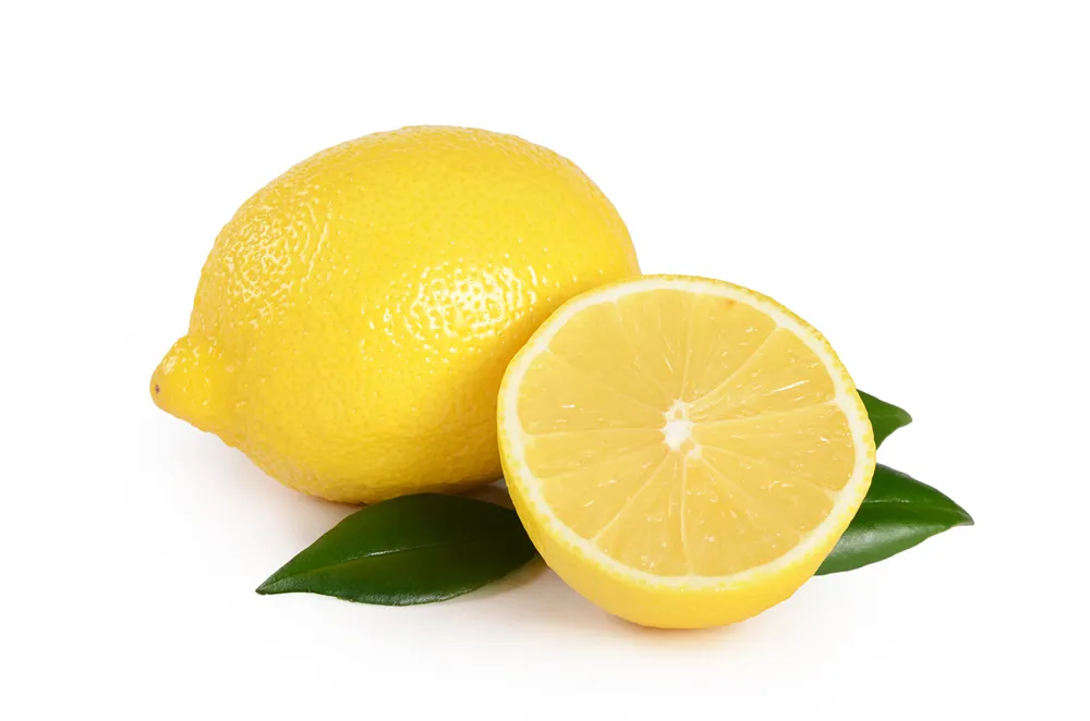 Un limone Femminiello Siracusano intero con una foglia verde e un limone tagliato a metà, entrambi con una buccia gialla brillante, posizionati su uno sfondo bianco.