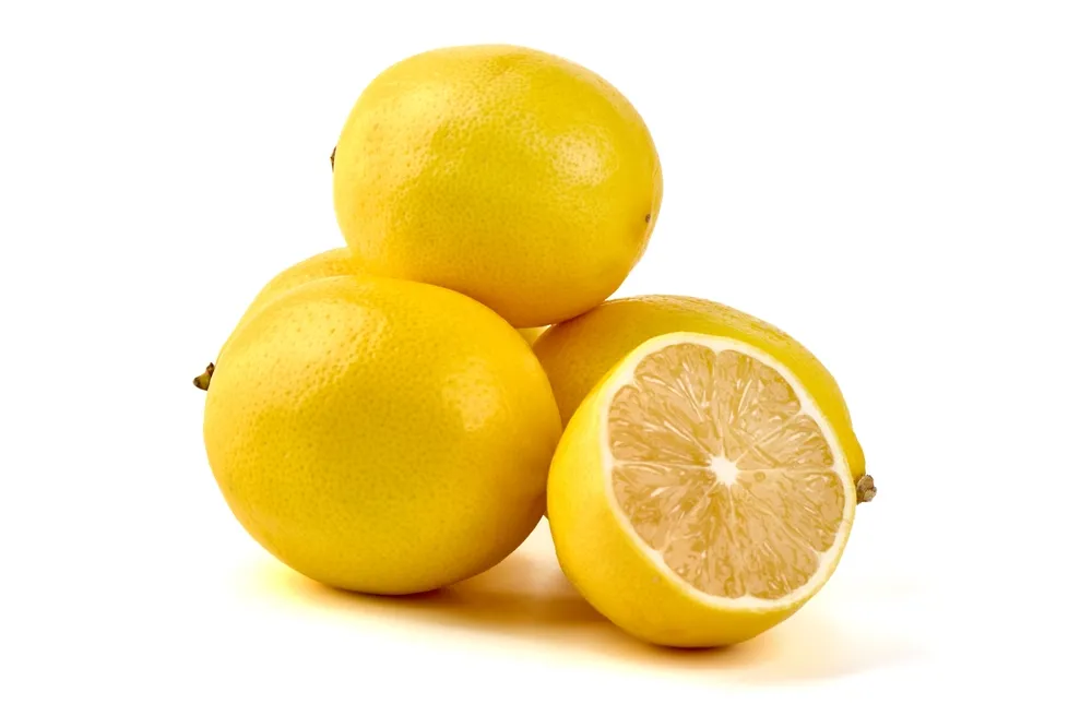 A group of three Meyer lemons on a white background, with one cut in half showing a juicy pulp and smooth, thin yellow-orange skin.